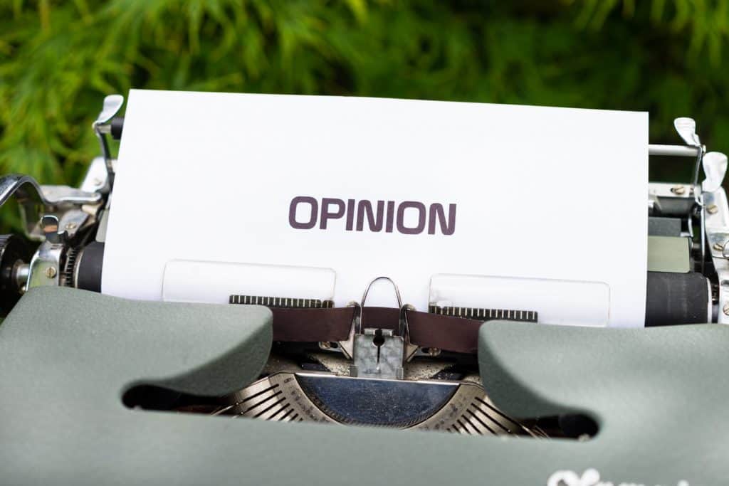 The word "Opinion" is seen on a piece of paper coming out of a typewriter