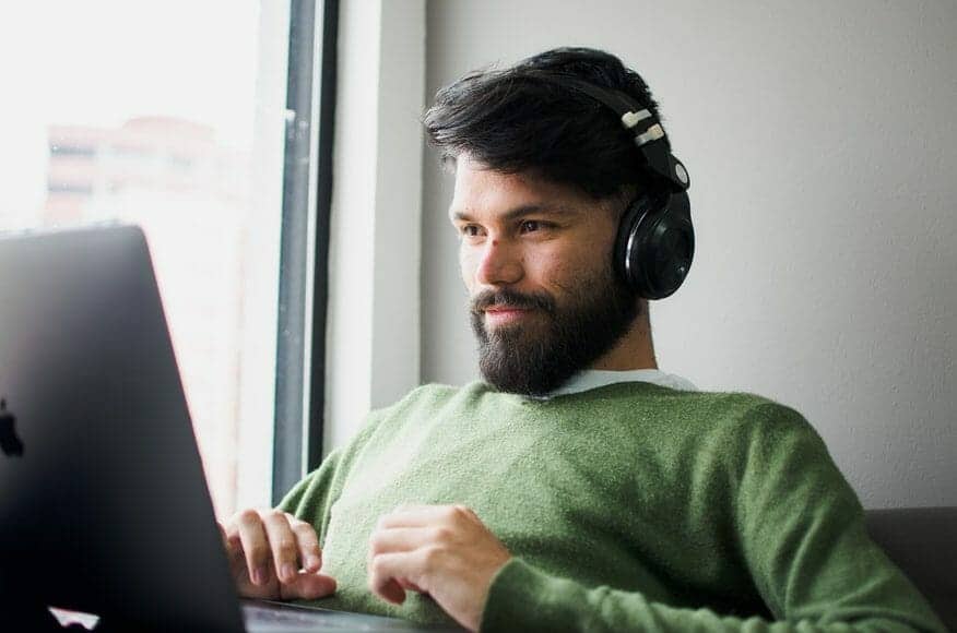 Man in over-ear headphones on laptop