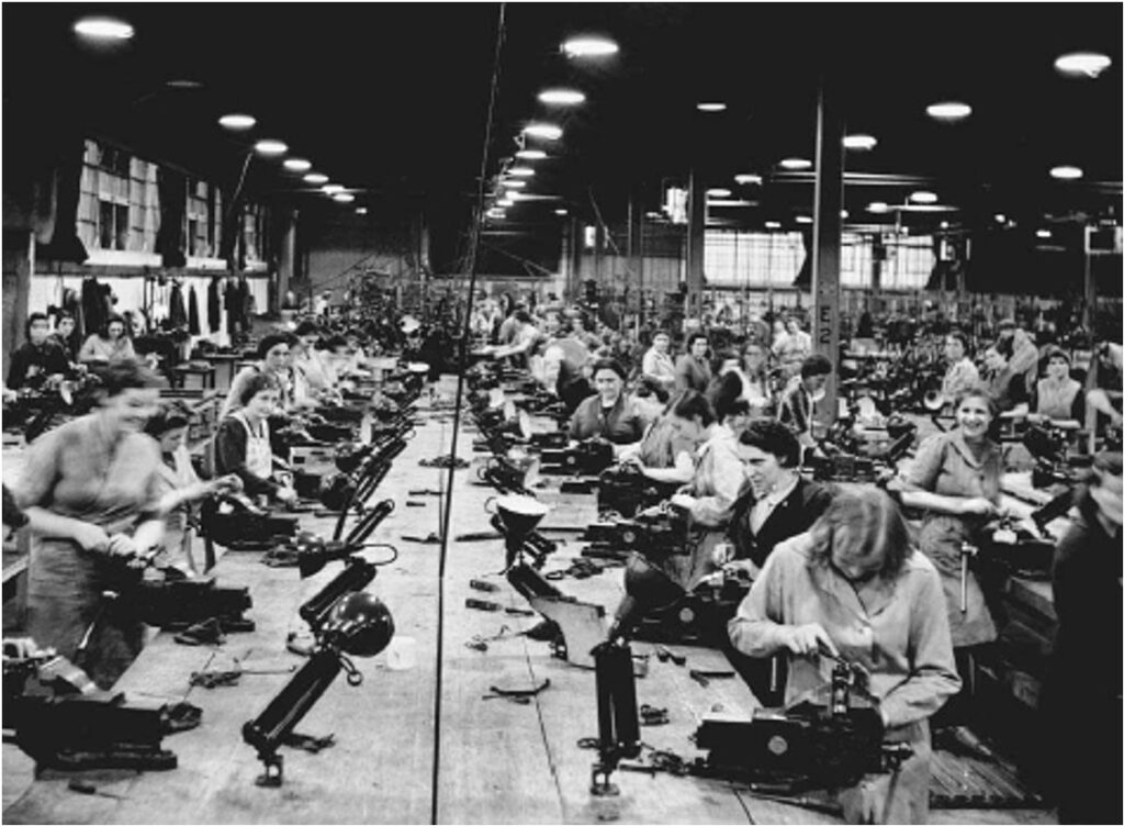 Women assemble small arms at a factory in England during World War II. 