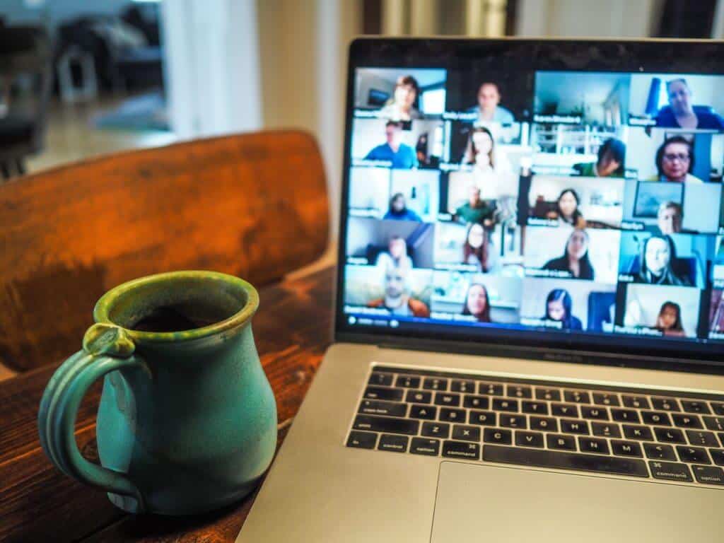 Photo of laptop during a virtual meeting and coffee cup