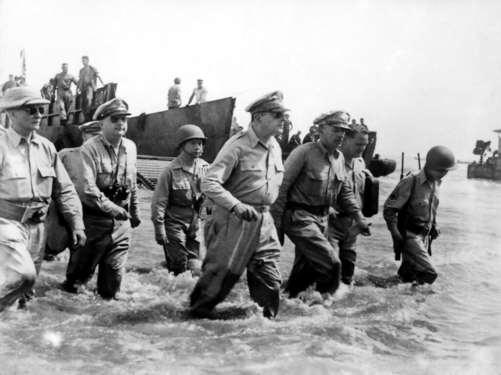 Douglas MacArthur wades ashore during initial landings at Leyte, Philippine Islands.